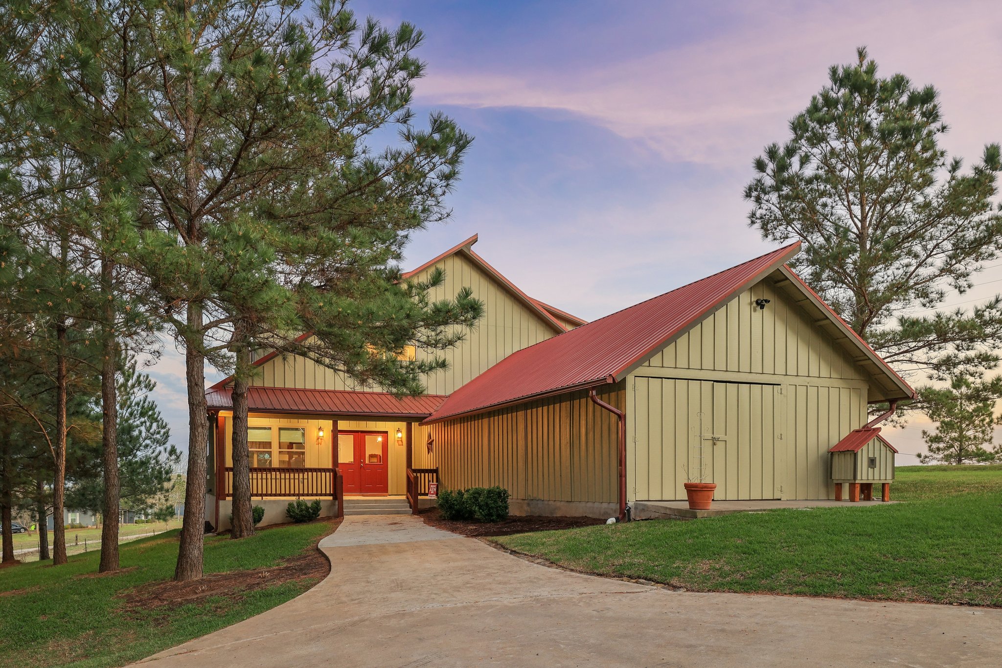 546 McAllister Road Bastrop, TX 78602 - Photo 6 of 40 View of front facade with a lawn, board and batten siding, a porch, driveway, and a metal roof