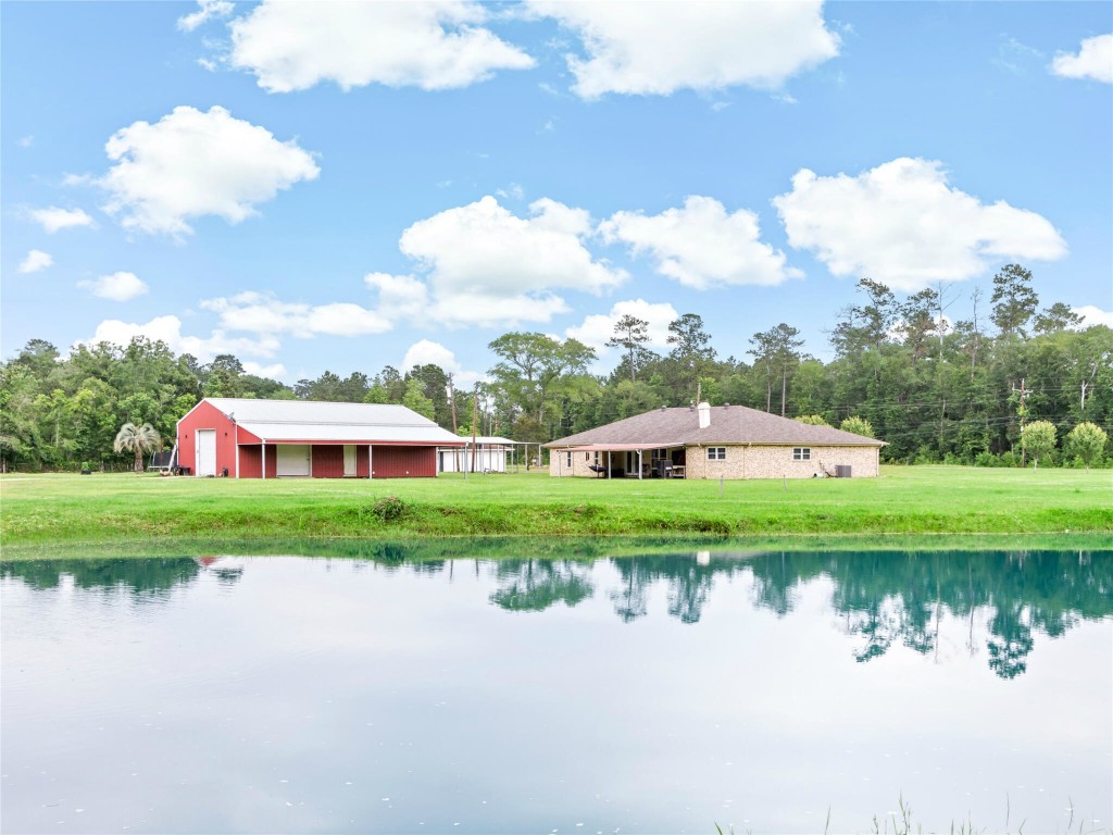 a view of a house with a yard and a pond
