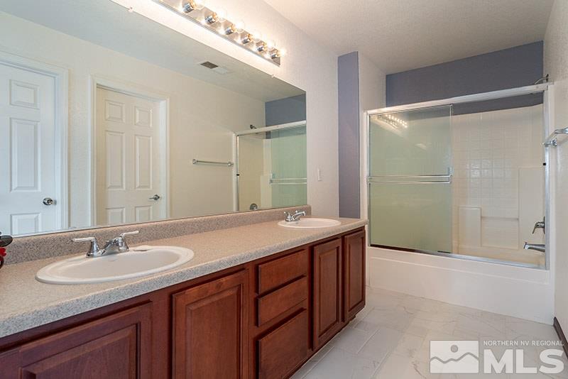 7725 Tulear Street Reno, NV 89506 - Photo 10 of 16 a bathroom with a granite countertop sink and mirror
