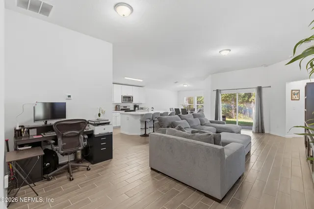a living room with furniture flat screen tv and a window