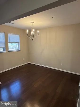 a view of an empty room with wooden floor and a bookshelf