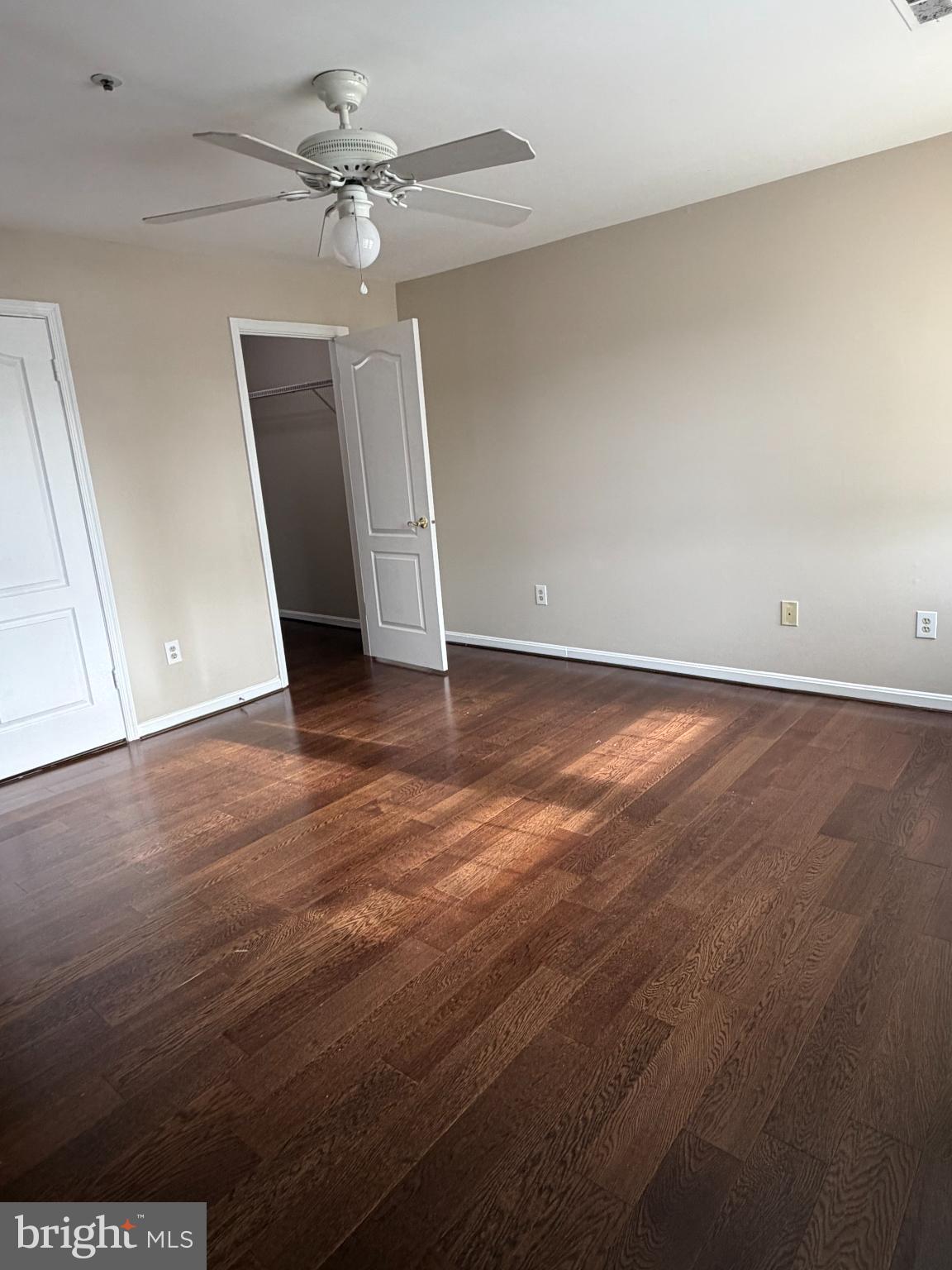 8571 Falls Run Road, Unit F Ellicott City, MD 21043 - Photo 11 of 15 an empty room with wooden floor and ceiling fan