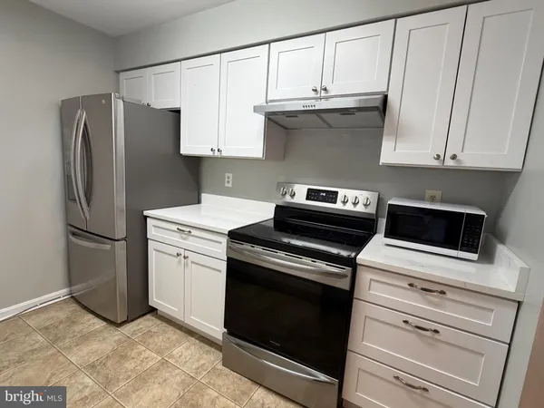 a kitchen with granite countertop white cabinets and stainless steel appliances