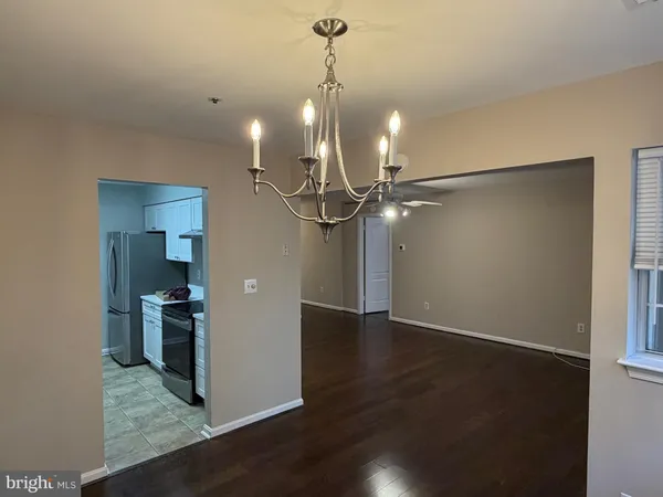 a view of a room with wooden floor and a ceiling fan