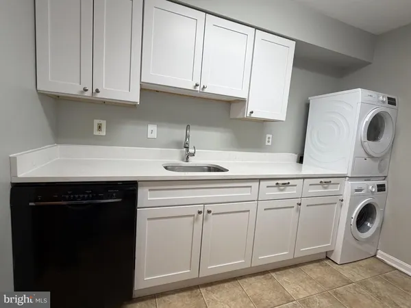 a kitchen with granite countertop white cabinets and sink