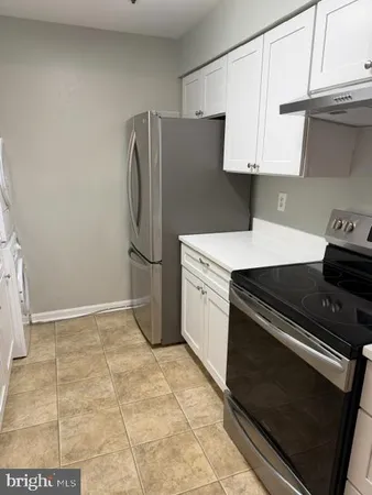 a kitchen with a stove a refrigerator and cabinets