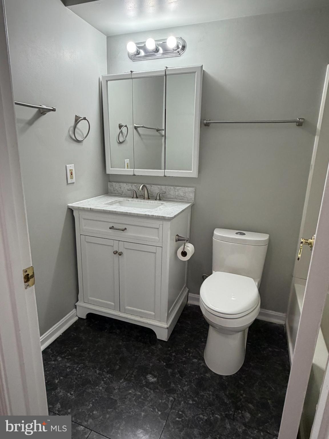 8571 Falls Run Road, Unit F Ellicott City, MD 21043 - Photo 6 of 15 a bathroom with a toilet sink and mirror