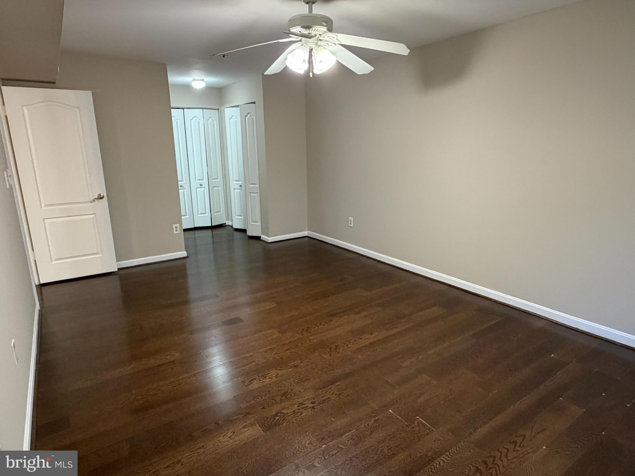 8571 Falls Run Road, Unit F Ellicott City, MD 21043 - Photo 7 of 15 an empty room with wooden floor chandelier fan and windows