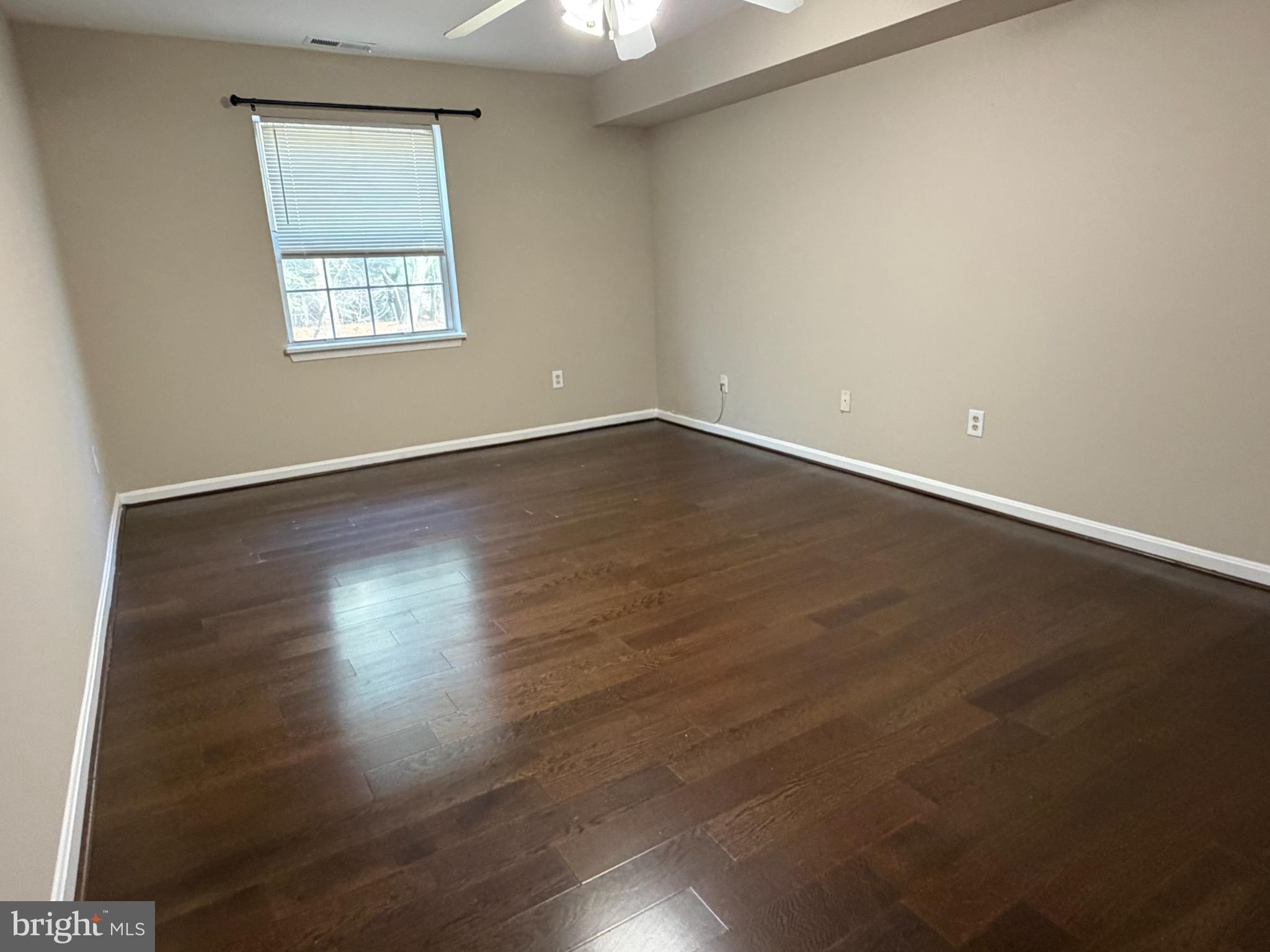 8571 Falls Run Road, Unit F Ellicott City, MD 21043 - Photo 8 of 15 an empty room with wooden floor and windows