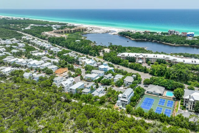 an aerial view of residential houses with outdoor space and lake view