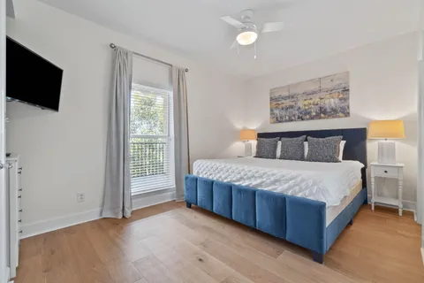 a bedroom with a large bed and a flat tv screen on dresser