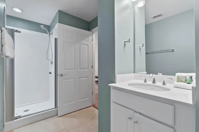 a bathroom with a sink mirror and shower