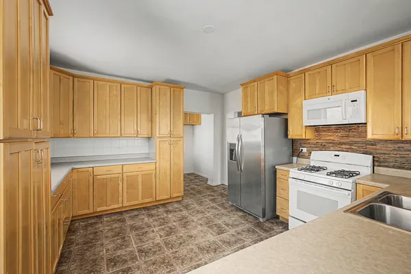 a kitchen with stainless steel appliances granite countertop a refrigerator stove top oven and sink