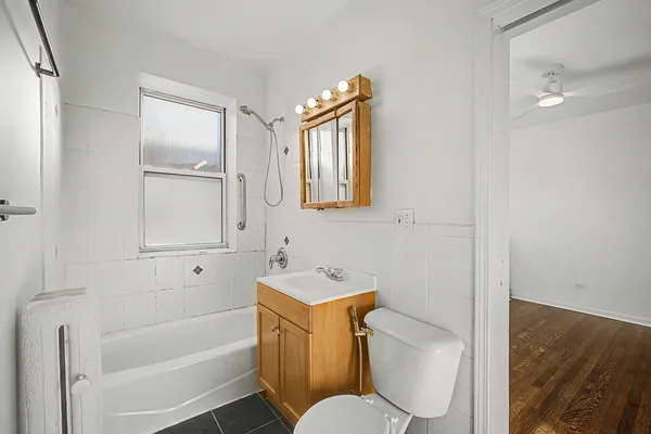 a bathroom with a sink a toilet a tub and shower