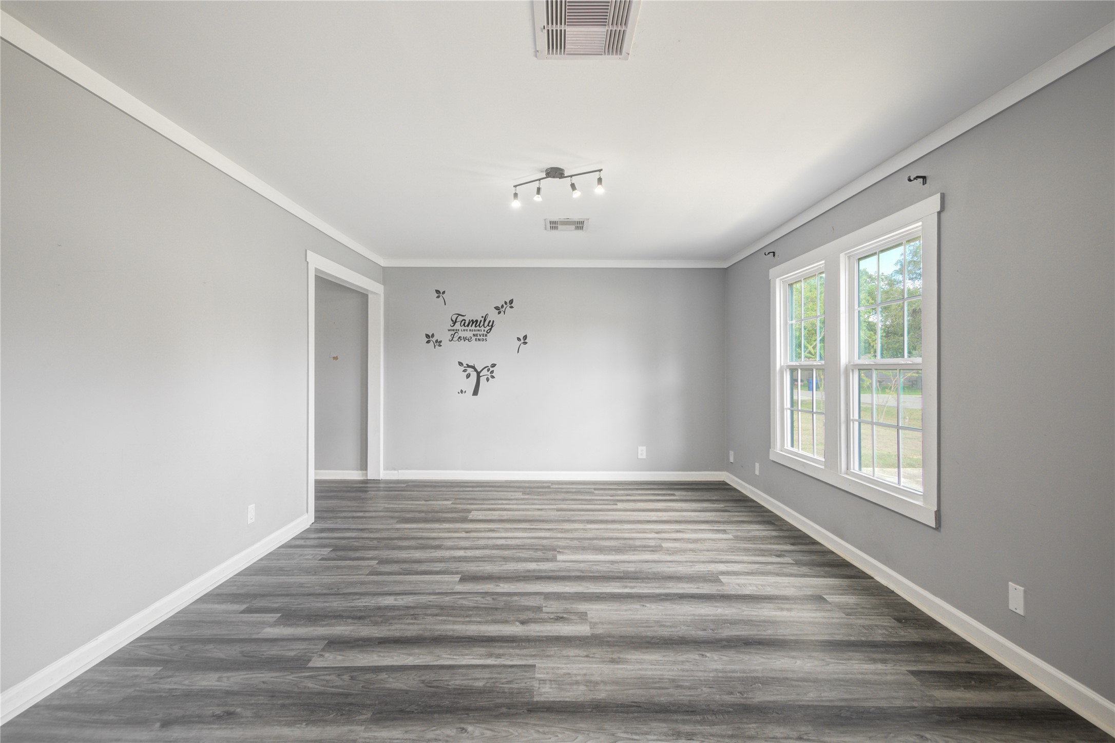 609 Hurst Place Angleton, TX 77515 - Photo 9 of 36 a view of an empty room with a window and wooden floor