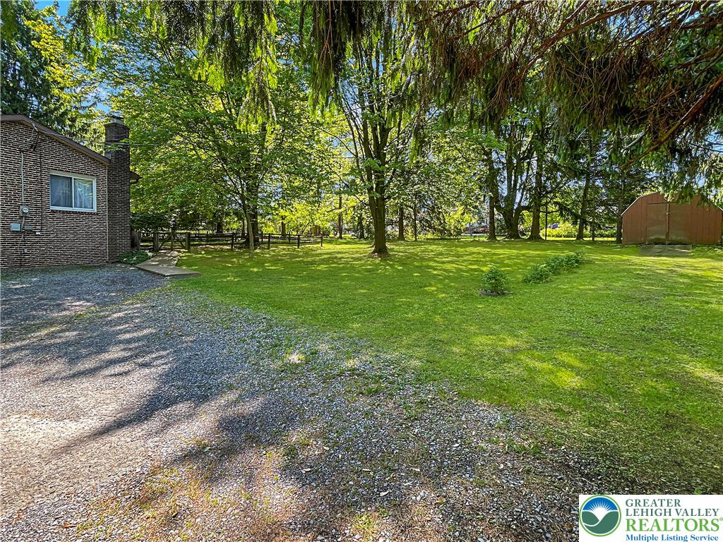 3406 Church Road Easton, PA 18045 - Photo 36 of 39 A verdant backyard offers a spacious lawn with mature trees and a charming storage shed.