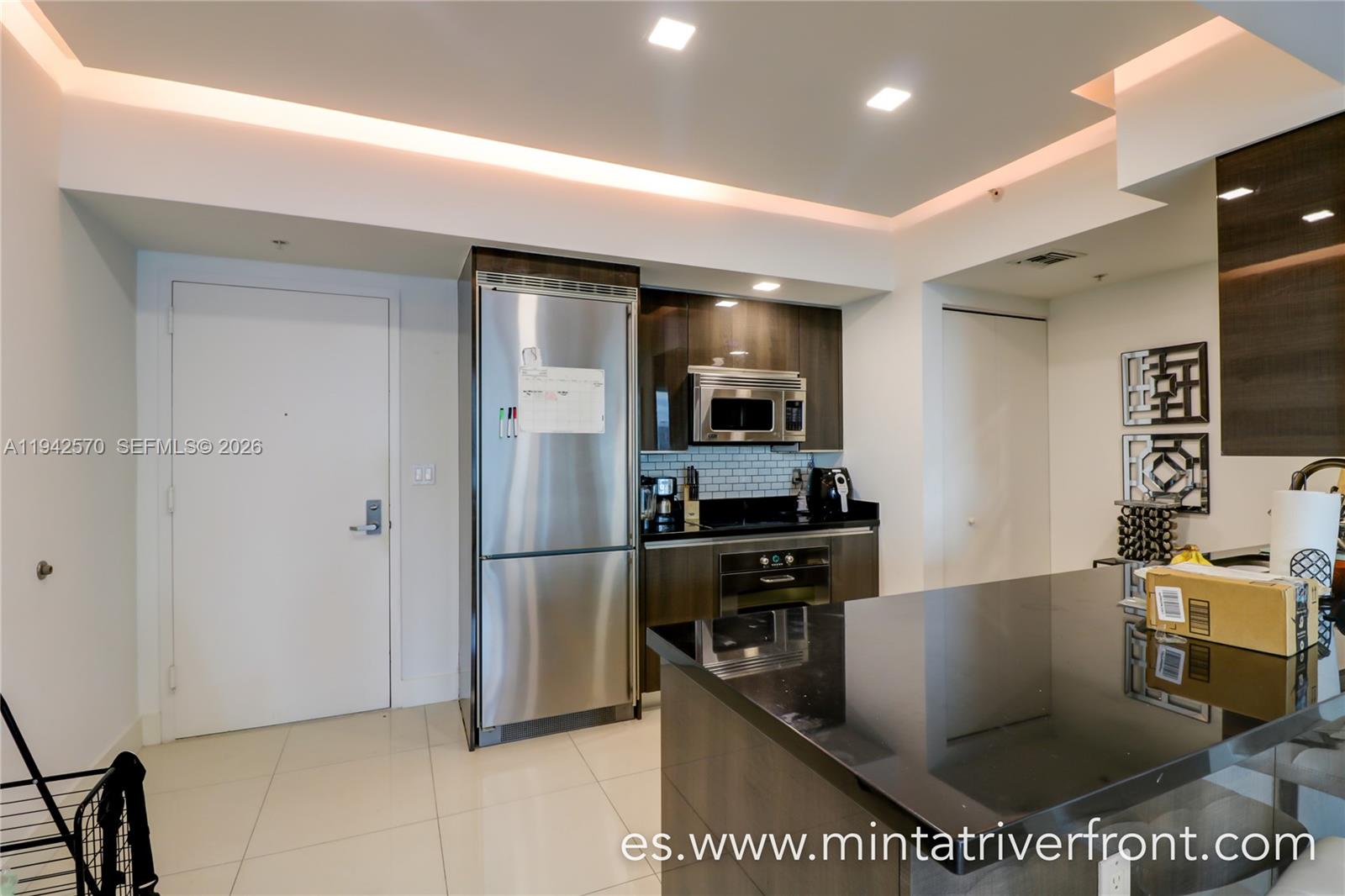 92 Southwest 3rd Street, Unit 1902 Miami, FL 33130 - Photo 2 of 9 a room with stainless steel appliances kitchen island granite countertop a refrigerator a stove and a sink with wooden floor