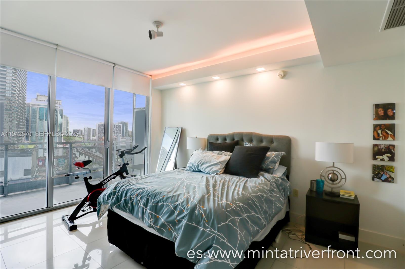 92 Southwest 3rd Street, Unit 1902 Miami, FL 33130 - Photo 7 of 9 a bed sitting in a bedroom next to a window