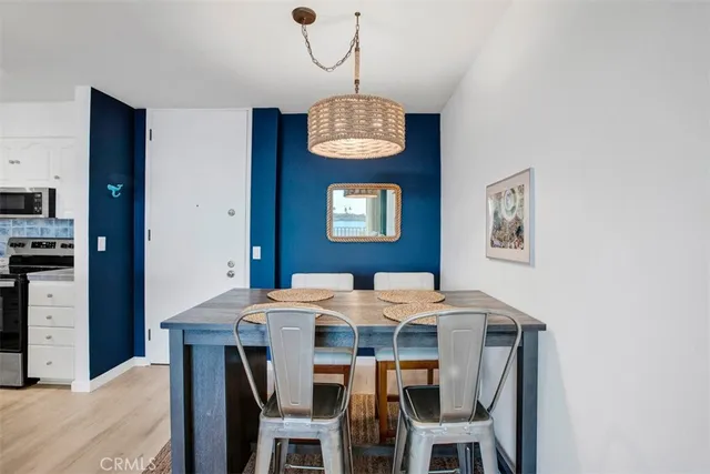 a kitchen with stainless steel appliances kitchen island a stove a table and chairs in it