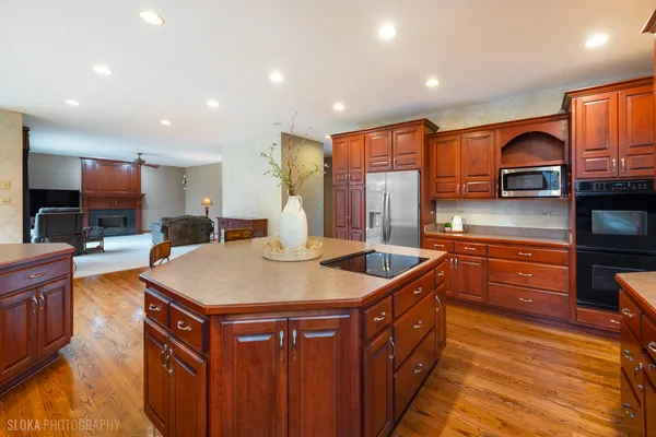 a kitchen with stainless steel appliances granite countertop a sink a stove and a wooden cabinets