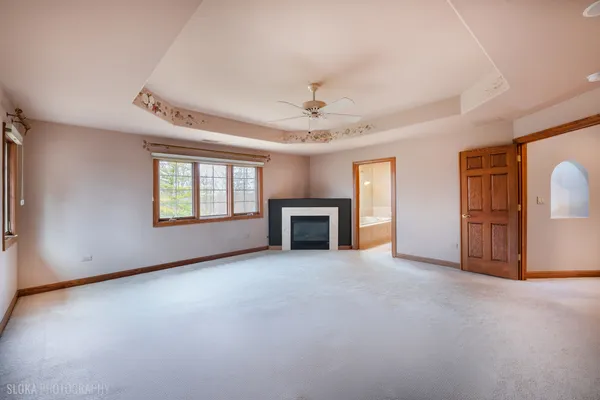 an empty room with windows and fireplace