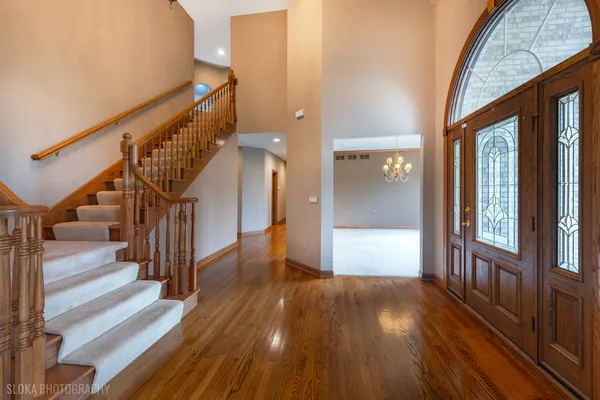 a view of entryway and hall with wooden floor