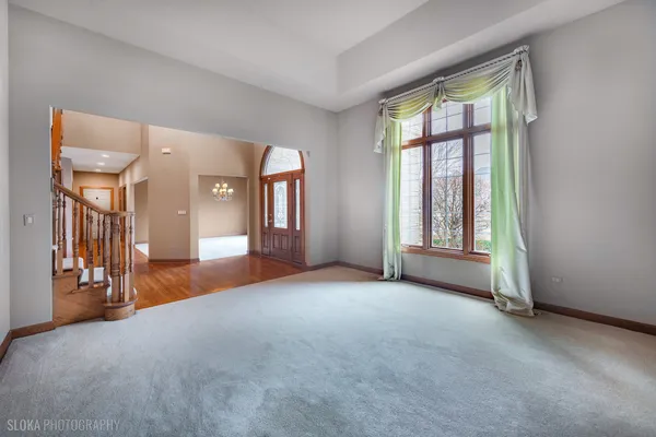 a view of a big room with windows and chandelier