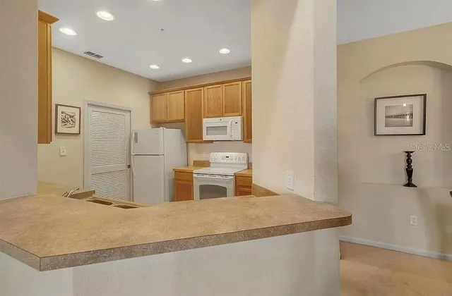 a kitchen with stainless steel appliances granite countertop a refrigerator and a stove
