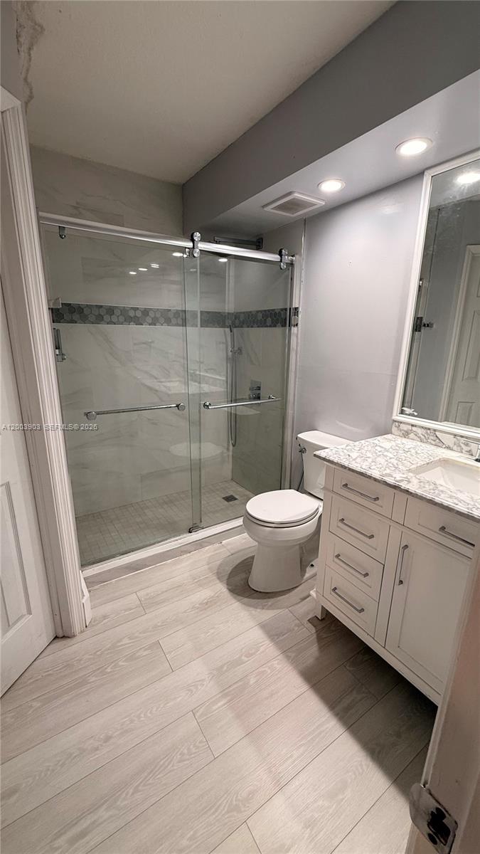 821 Lyons Road, Unit 21102 Coconut Creek, FL 33063 - Photo 5 of 17 a bathroom with a granite countertop sink toilet and shower