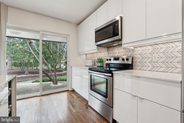 a kitchen with granite countertop a stove a sink and a microwave