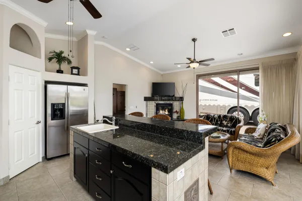 a kitchen with kitchen island granite countertop a sink cabinets and stainless steel appliances