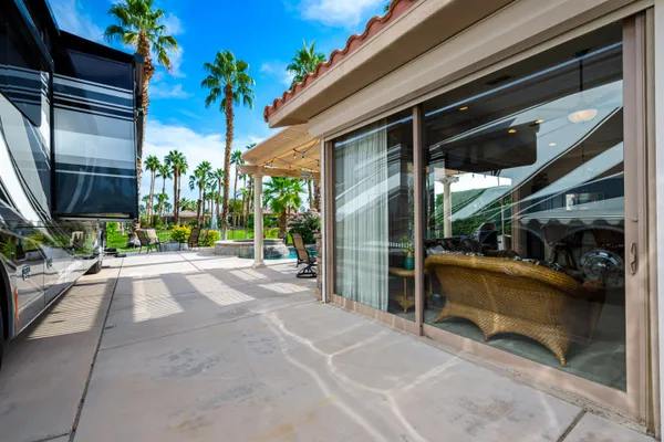 a view of backyard with wheel chair potted plant and large windows