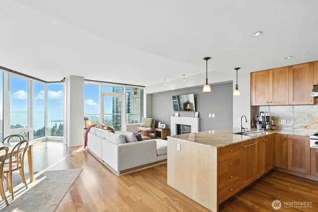 a living room with furniture a large window and wooden floors