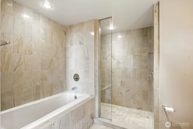 a bathroom with a double vanity sink mirror and bathtub