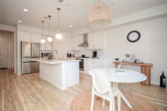 a kitchen with a sink appliances cabinets and dining table