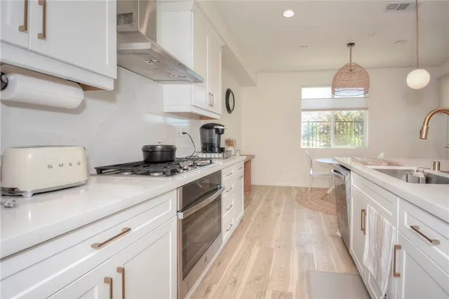 a kitchen with a stove a sink and a window