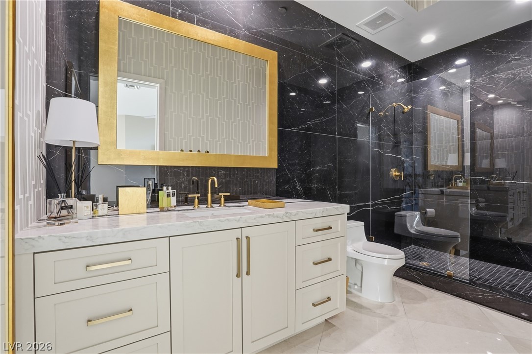 360 East Desert Inn Road, Unit 1701 Las Vegas, NV 89109 - Photo 26 of 33 Luxurious bathroom with a spacious vanity, golden fixtures, and a glass-enclosed shower.