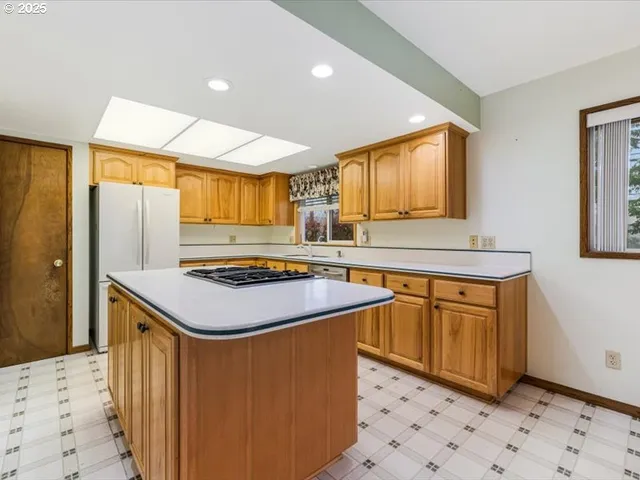 a kitchen with stainless steel appliances granite countertop a stove a sink and a refrigerator