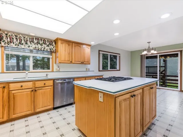 a kitchen with stainless steel appliances granite countertop a stove a sink dishwasher and a refrigerator with wooden floor