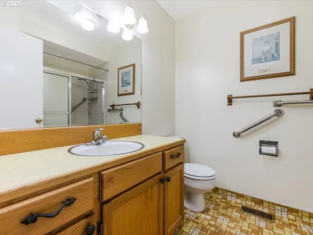 a bathroom with a granite countertop sink mirror vanity and toilet