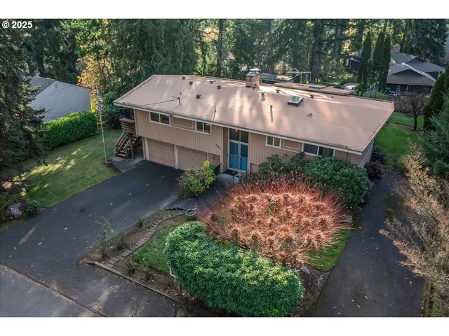 a aerial view of a house with a yard and large tree