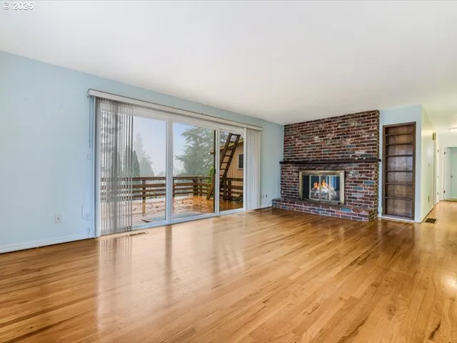 wooden floor fireplace and windows in an empty room