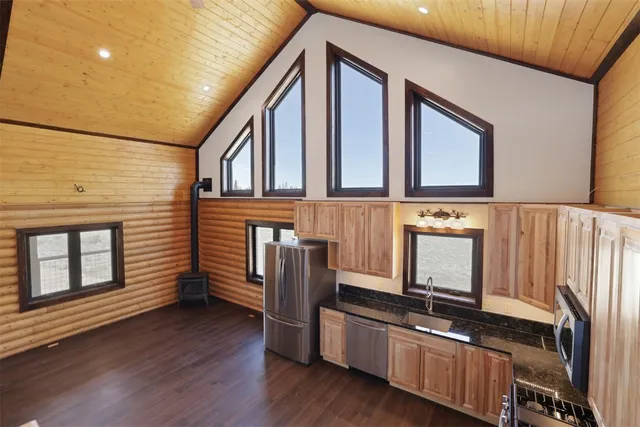 a view of kitchen with stainless steel appliances granite countertop a stove and a wooden floors