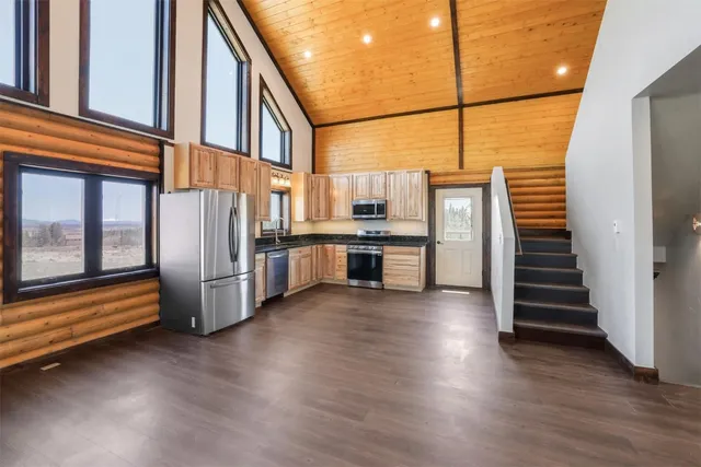 a view of a kitchen with wooden floor and electronic appliances