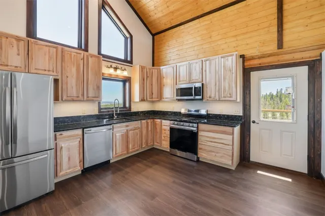 a kitchen with granite countertop white cabinets and white appliances