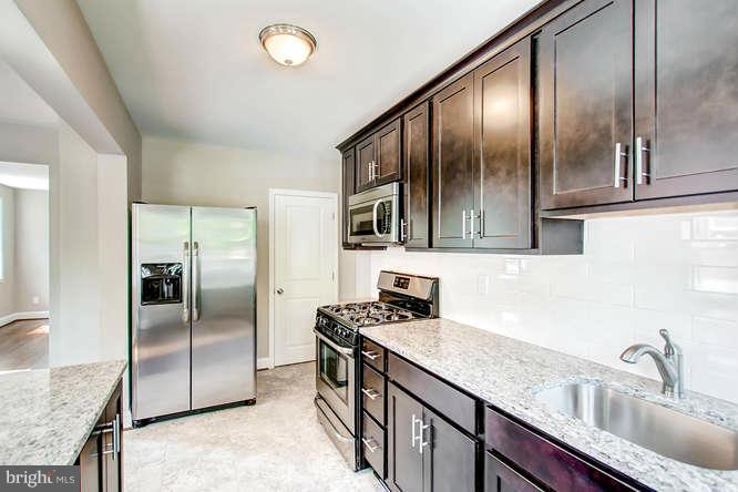 543 Welbrook Road Baltimore, MD 21221 - Photo 12 of 28 a kitchen with stainless steel appliances granite countertop a sink and a refrigerator
