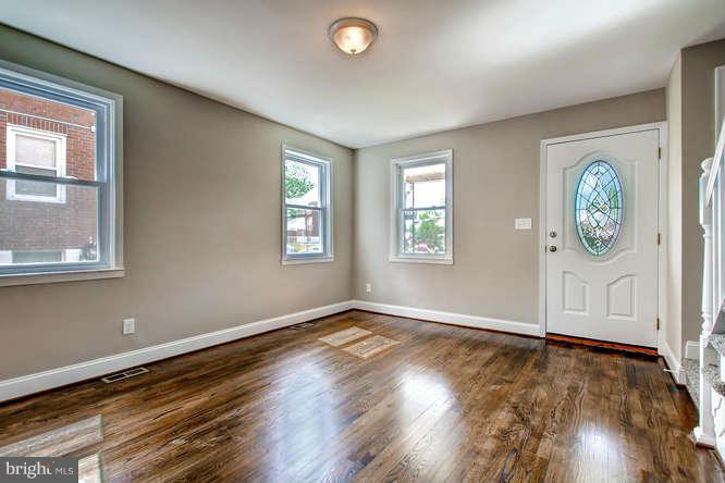 543 Welbrook Road Baltimore, MD 21221 - Photo 5 of 28 an empty room with wooden floor and windows