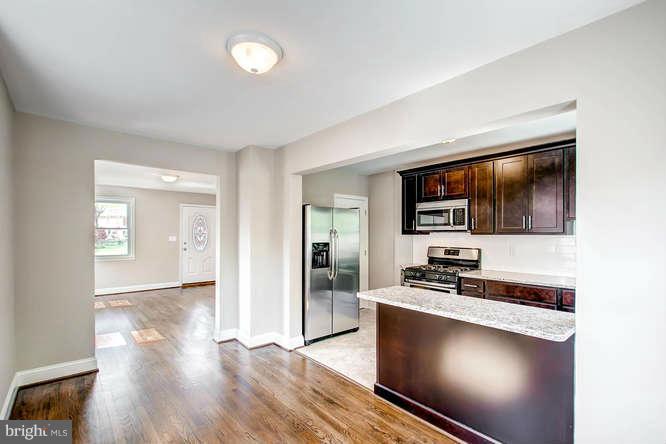 543 Welbrook Road Baltimore, MD 21221 - Photo 9 of 28 a living room with stainless steel appliances kitchen island granite countertop a stove a sink and a microwave
