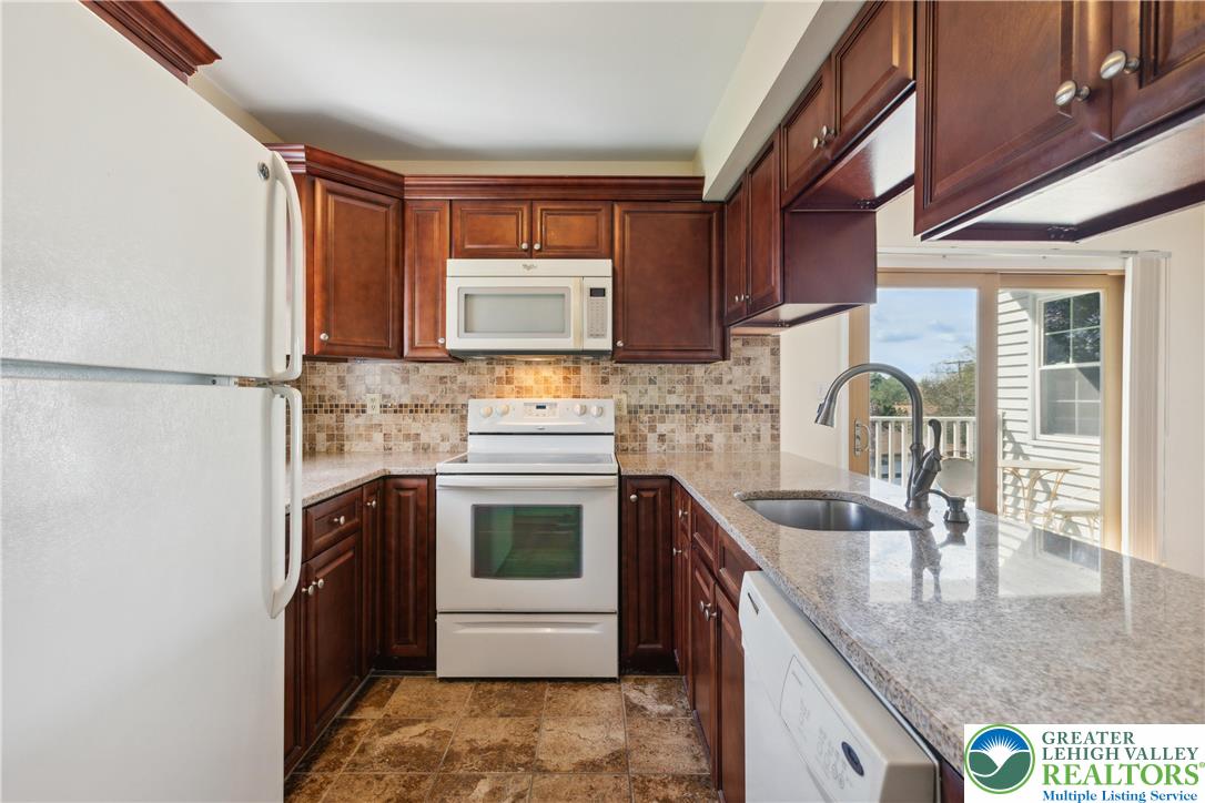 110 Drift Court, Unit B Bethlehem, PA 18020 - Photo 13 of 25 a kitchen with stainless steel appliances granite countertop a sink stove and refrigerator