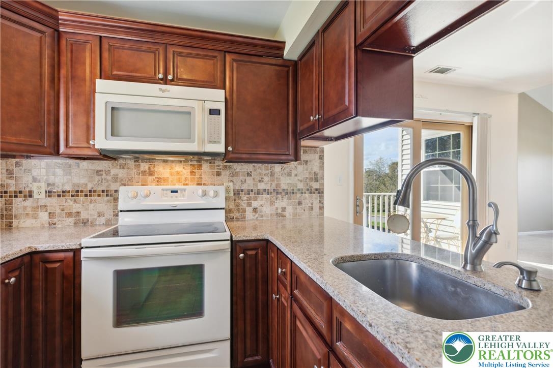 110 Drift Court, Unit B Bethlehem, PA 18020 - Photo 14 of 25 a kitchen with granite countertop a sink stove and cabinets